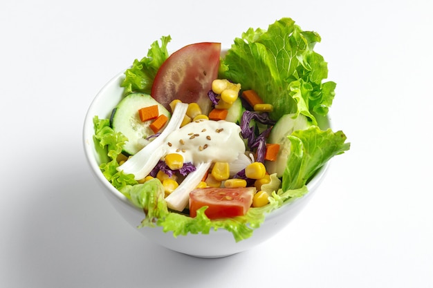 Verse sla salade met tomaten, rode ui, maïs, wortelen, komkommer