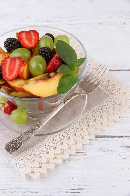 Verse smakelijke fruitsalade op houten tafel