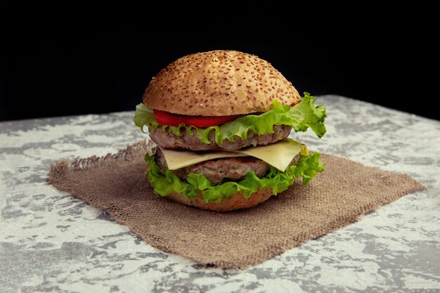 Verse smakelijke hamburger geïsoleerd op rustieke ondergrond