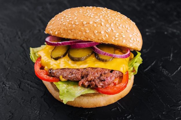 Verse smakelijke hamburger op zwarte achtergrond