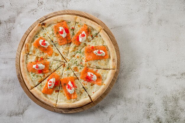 Foto verse smakelijke pizza met zalm en kaas op de betonnen achtergrond