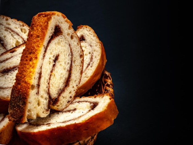 Verse smakelijke strudel met kaneel gesneden op een zwarte achtergrond