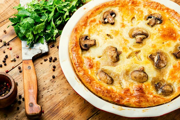 Verse taart met vlees en champignons. Zelfgemaakte vleestaart op houten tafel