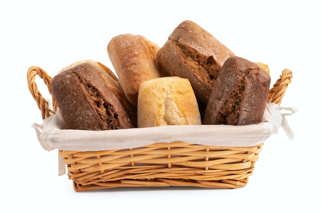 Foto verse tarwe en roggebroodjes in een rieten mand die op wit wordt geïsoleerd