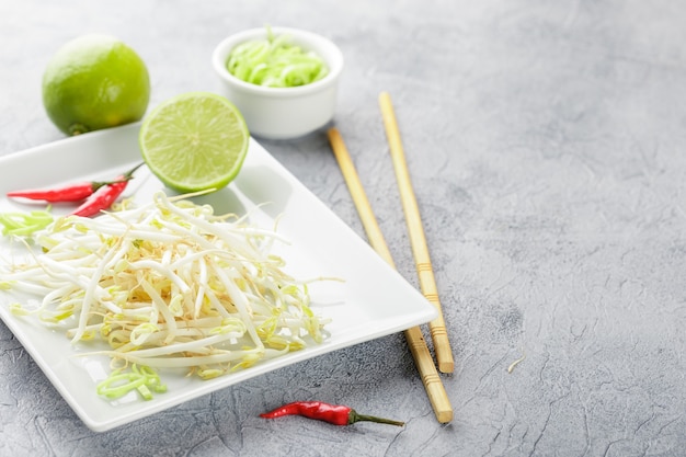 Verse taugé op witte vierkante plaat en eetstokjes. concept van gezond voedsel, vegetarisch eten.