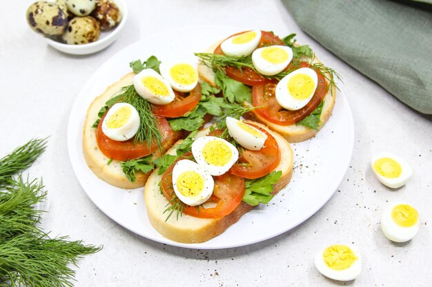 Foto verse toast sandwiches met kwartel eieren tomaten en groene kruiden close-up top view