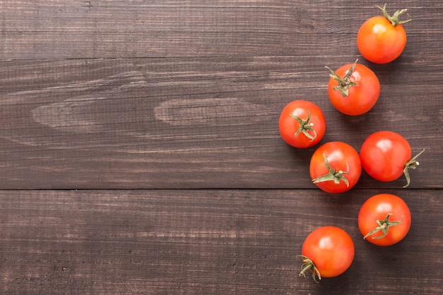 Verse tomaat op de bruine houten achtergrond. bovenaanzicht