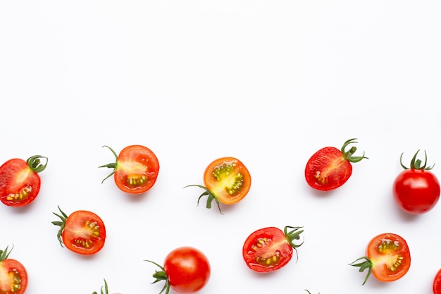 Verse tomaten, gehele en halve die besnoeiing op witte achtergrond worden geïsoleerd.