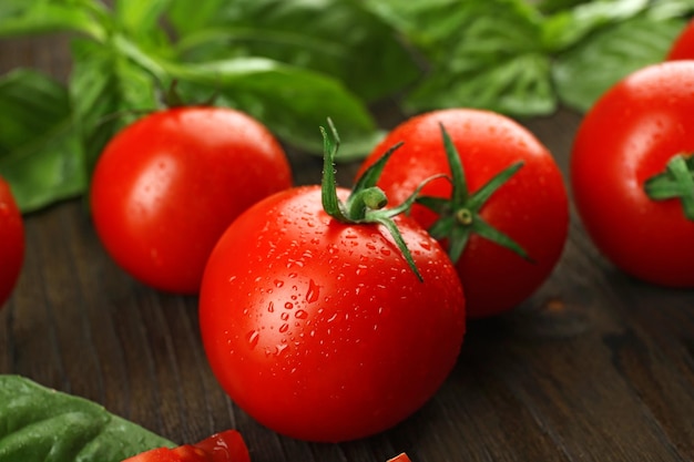 Verse tomaten met basilicum op houten tafel close-up