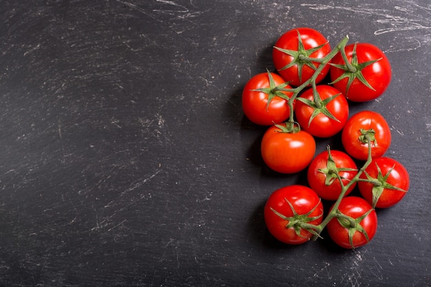 Verse tomaten op donkere tafel, bovenaanzicht met kopie ruimte