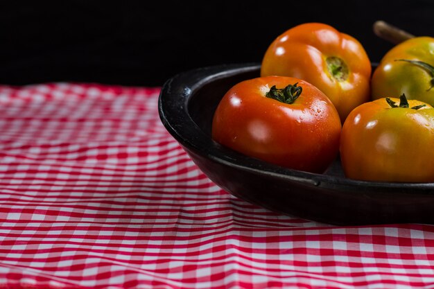 verse tomaten op zwarte plaat op geruite doek