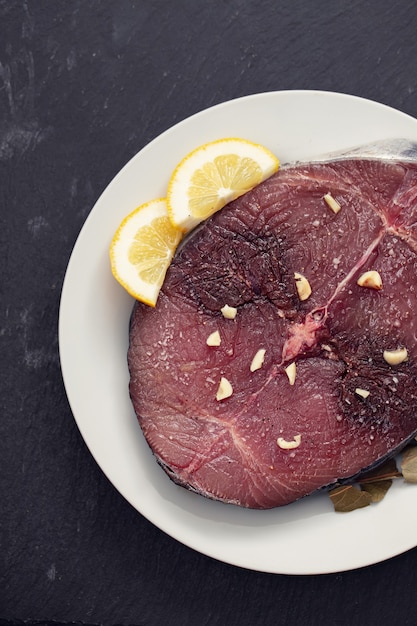 Verse tonijn met citroen op witte plaat