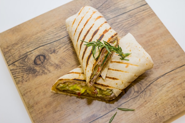 Verse tortilla wraps met kip en verse groenten op houten plaat