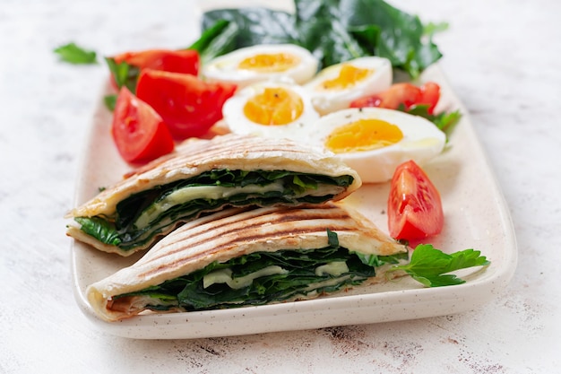 Verse tortilla wraps met spinazie en kaas op lichte achtergrond Gezonde voeding concept Vegetarisch eten