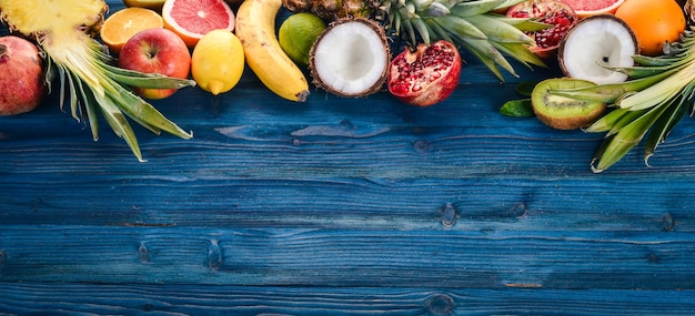Verse Tropische Vruchten Ananas Kokos Kiwi Sinaasappel Granaatappel Grapefruit Op een houten achtergrond Bovenaanzicht Vrije ruimte voor tekst