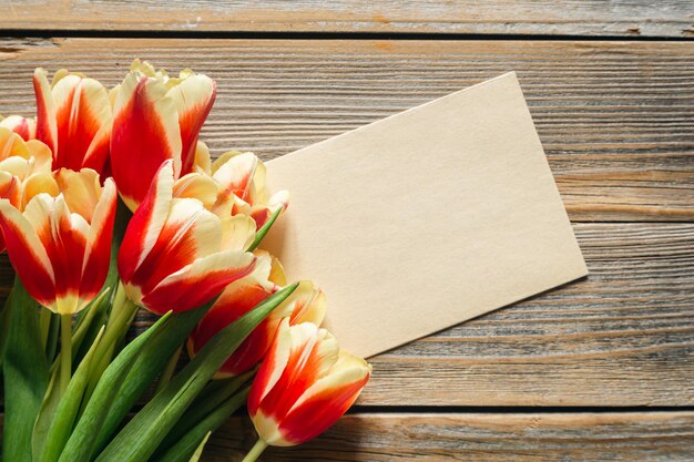 Foto verse tulpen op een vlakke houten achtergrond groetekaart sjabloon met ruimte voor tekst