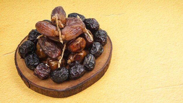 Verse verschillende dadels fruit kurma over gele achtergrond