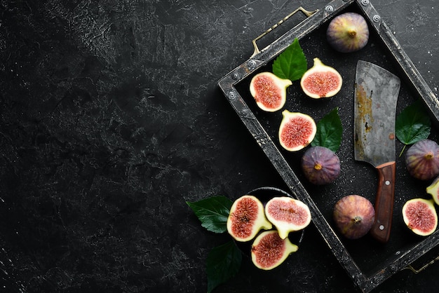 Verse vijgen op zwarte stenen achtergrond Tropisch fruit Bovenaanzicht Gratis exemplaarruimte