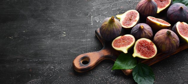 Verse vijgen op zwarte stenen achtergrond Tropisch fruit Bovenaanzicht Gratis kopieerruimte