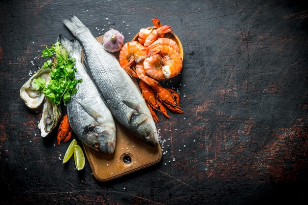 Verse vis op een snijplank met oesters, garnalen en rivierkreeften