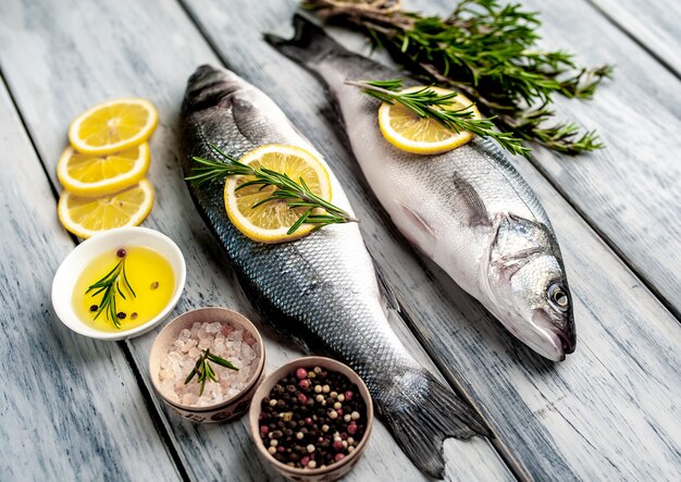 Verse vis zeebaars. Zeebaars rauwe vis met ingrediënten kruiden en kruiden op houten achtergrond