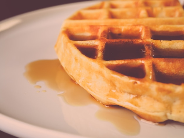 Verse wafel met zoete stroop in witte plaat.