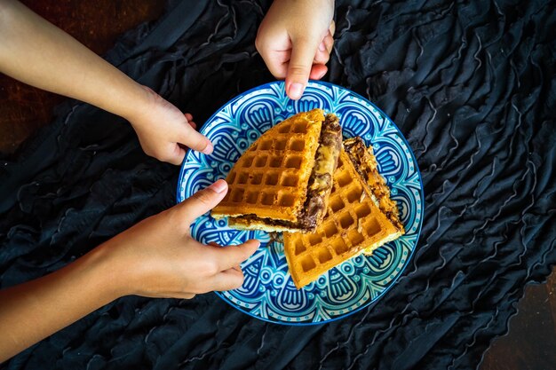 Foto verse wafels met pindakaas en chocolade op een versierd bord