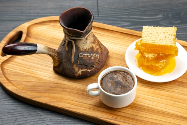Verse warme koffie met kalkoen en honingraat op een houten keukenplank. nuttig vitaminevoedsel