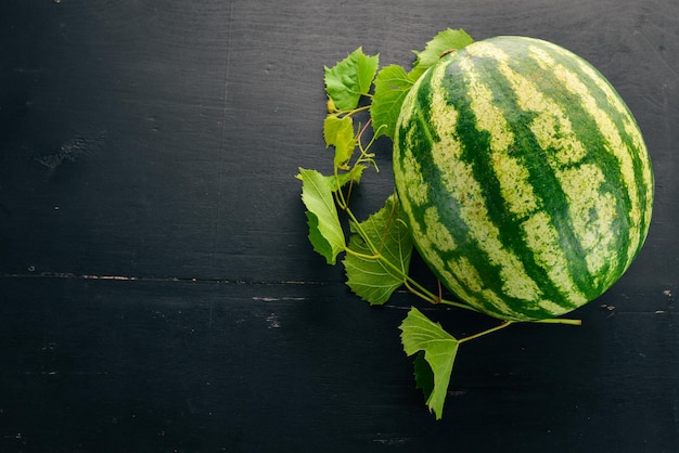 Verse watermeloen Fruit Meloen Op een zwarte houten achtergrond Vrije ruimte voor tekst Bovenaanzicht