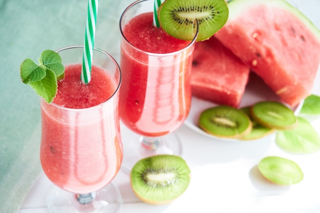 Verse watermeloen smoothie met kiwi en munt op een witte tafel