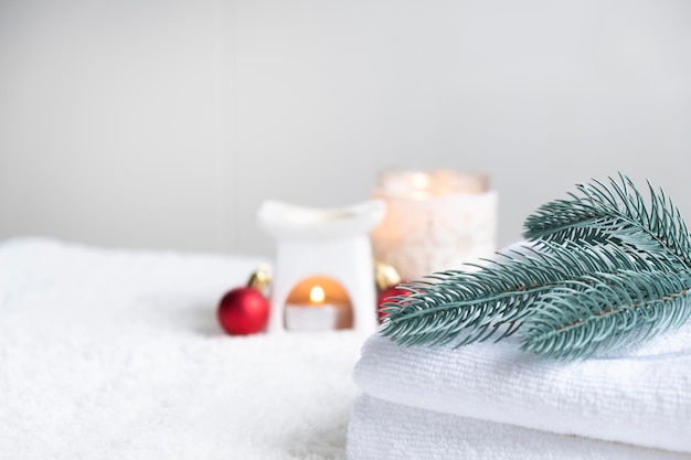 Foto verse witte handdoeken met dennenkaarsen en kerstversieringen.