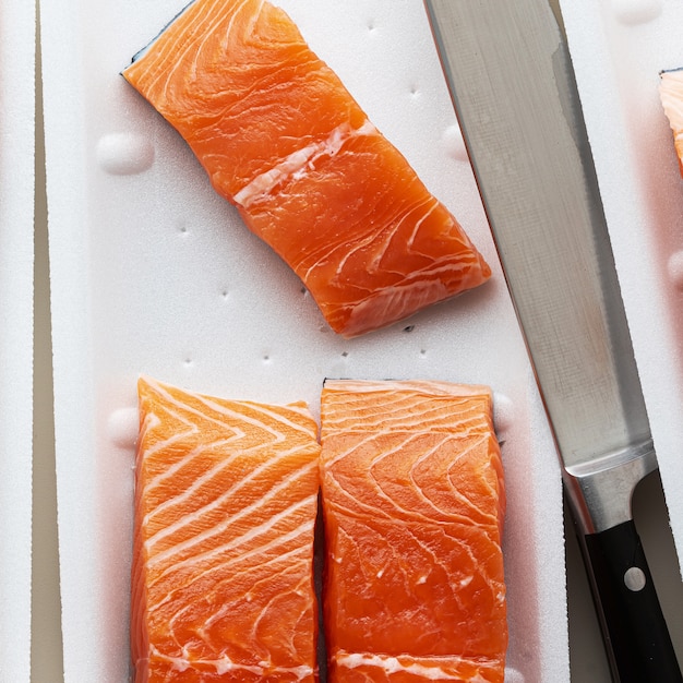 Verse zalm, in stukjes gesneden en klaar om te koken, en een groot koksmes.