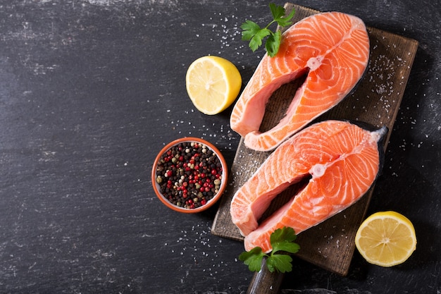 Verse zalmlapjes vlees met ingrediënten voor het koken op een houten bord, bovenaanzicht