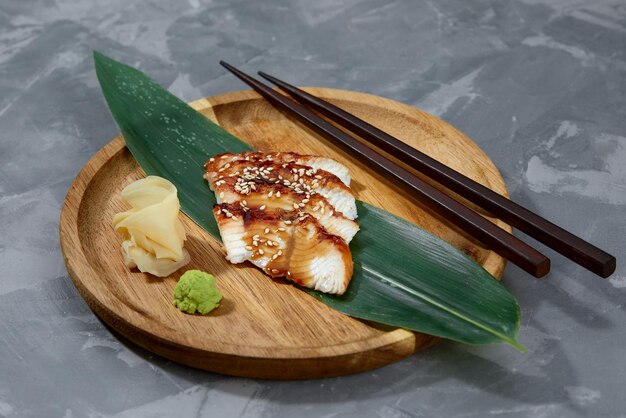 Verse zeevruchten sashimi gerookte paling op leisteen bord met wasabi en gember op zwarte achtergrond