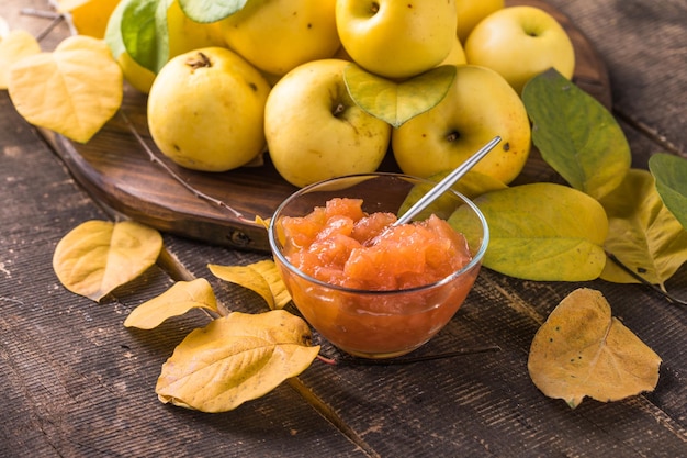 Foto verse zelfgemaakte appelmarmelade jam in glazen pot op een houten ondergrond. diverse verse appels