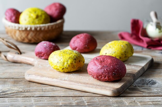 Verse zelfgemaakte gele en roze broodjes gemaakt met zaden, volkorenmeel en natuurlijke kleurstoffen zoals rode biet en kurkuma