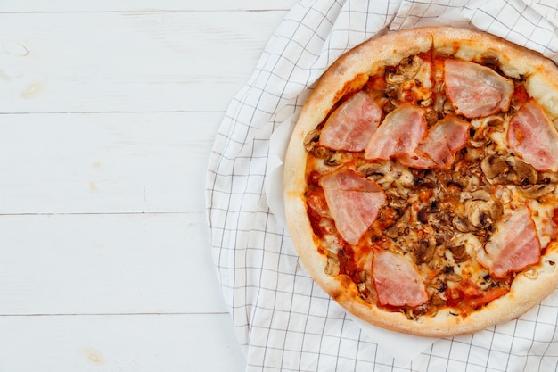 Verse zelfgemaakte gesneden pizza op witte houten tafelblad weergave