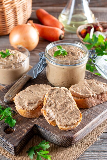 Verse zelfgemaakte kippenleverpastei op brood op rustieke houten achtergrond