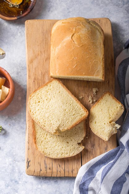 Verse zelfgemaakte krokante brood en plakjes met olijfolie, boter en groene olijven, bovenaanzicht. Bakken