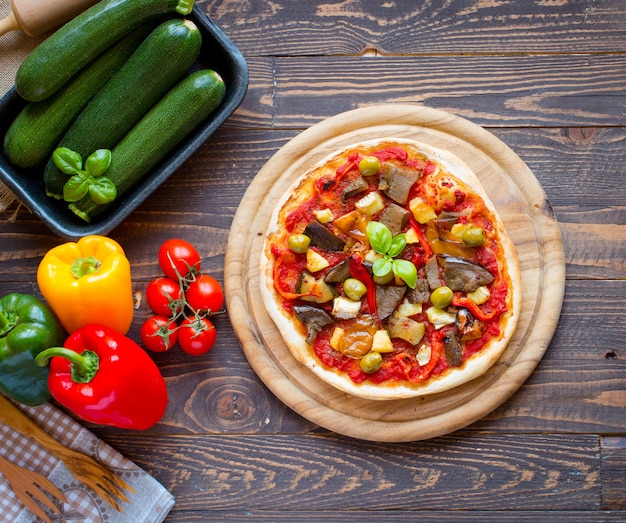 Verse zelfgemaakte pizza met verschillende groenten op een houten achtergrond