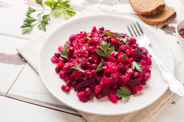 Verse zelfgemaakte rode biet salade Vinaigrette in een witte kom. Traditioneel Russisch eten.