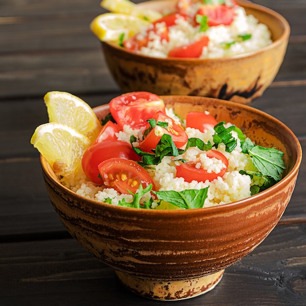 Verse zelfgemaakte tabouli of tabouleh salade zijaanzicht op donkere houten ondergrond