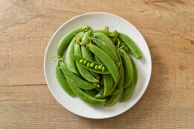 verse zoete groene erwten op witte plaat