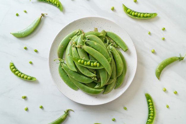 verse zoete groene erwten op witte plaat