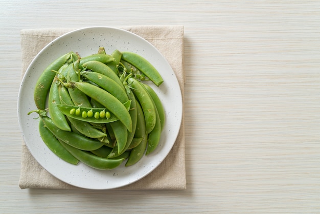 Verse zoete groene erwten op witte plaat