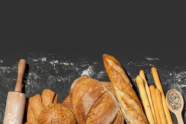 Versgebakken brood op een grijze donkere achtergrond Achtergrond met broodjes en stokbrood