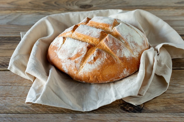 Versgebakken brood op houten grijze keukentafel, zelfgemaakt gebak.