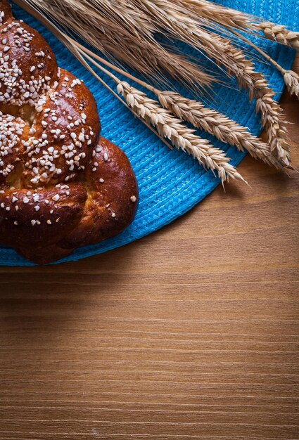 Versgebakken broodje tarwe rogge oren met rieten tafelkleed op houten bord eten en drinken concept