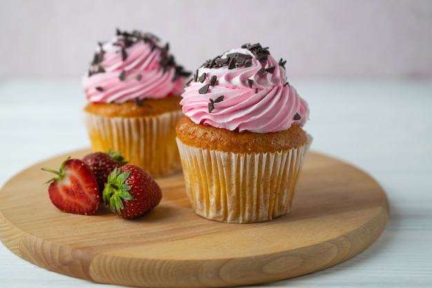 Versgebakken cakejes met roze aardbeien glazuur en hagelslag