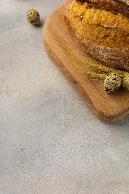 Versgebakken tarwebrood op een houten bord op een lichte ondergrond